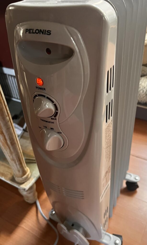 Pelonis PHO15A2AGW oil-filled radiator heater — close-up of the heat level switch and thermostat control