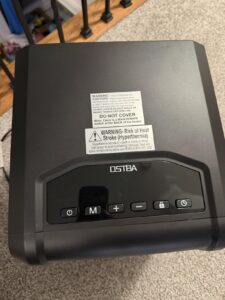 Top control panel and safety labels on an infrared space heater with timer and lock buttons