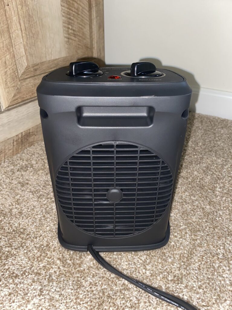 Rear view of the Aikoper portable space heater showing control knobs and carry handle