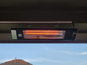 Ceiling-mounted Dr. Infrared Heater DR-238 infrared patio heater glowing under a covered porch roof