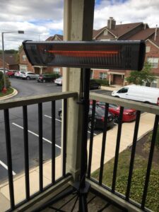 Heat Storm HS-1500-TT tripod infrared heater on an apartment balcony, angled for outdoor warmth