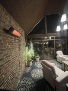 Dr. Infrared Heater DR-238 mounted on a brick wall warming a covered patio seating area at night