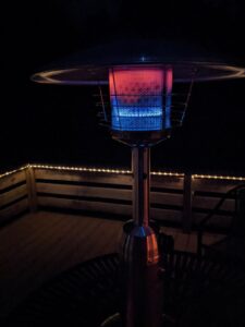 Close-up of the Fire Sense 60262 tabletop patio heater burner glowing red and blue beneath the metal heat reflector