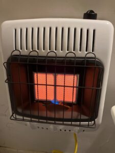 Wall-mounted Mr. Heater F299811 natural gas radiant heater with glowing ceramic tiles