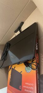 Back view of the Cozy Products Cozy Legs CL-2 heater showing cord and mounting hardware in the box