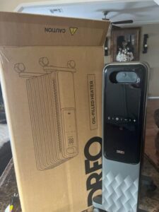 Dreo DR-HSH010 oil-filled heater next to its product box showing the radiator design