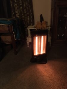 Comfort Zone halogen space heater warming a carpeted living room at night