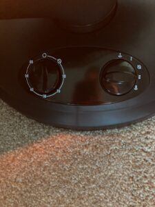 Close-up of Kismile space heater controls showing the timer dial and power setting knob